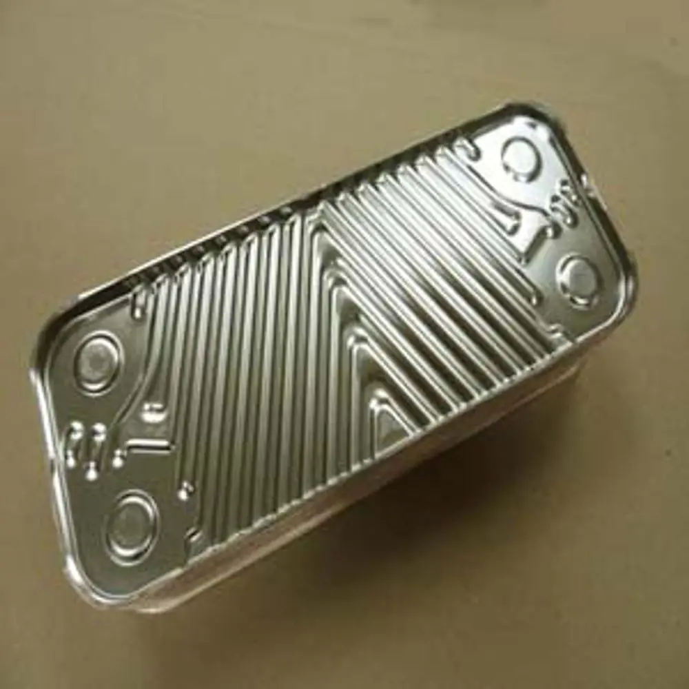 Remeha Plattenwärmetauscher aus Metall mit gewellter Oberfläche, rechteckiger Form und runden Ausschnitten an den Ecken, auf einem neutralen Untergrund.